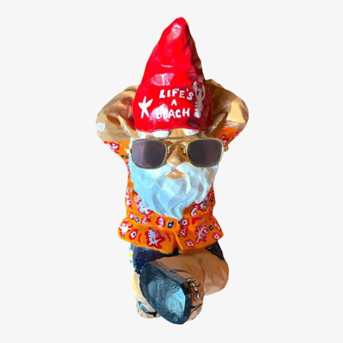 Garden Gnome with Life's A Beach written on red hat in white paint wearing sunglasses, flip flops, hands behind head, crossed leg, laying on back