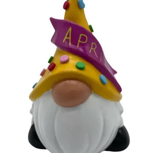 Birthday Gnome for April, wearing yellow hat with multi-colored dots has a pink banner that says April in yellow writing, Front