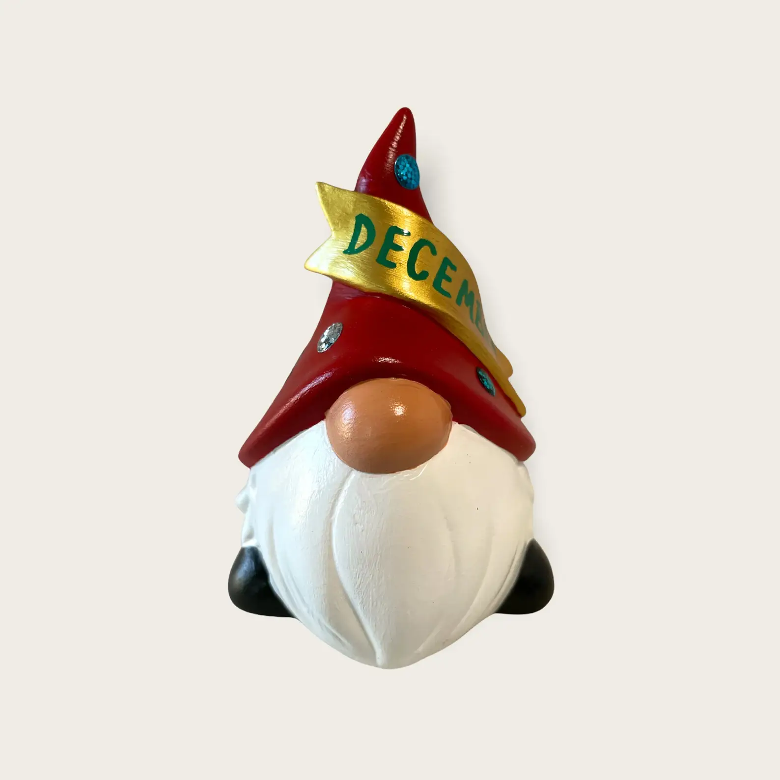 Birthday Gnome for December wearing red hat with snowflakes, and a gold banner across that reads December in Green, Front.